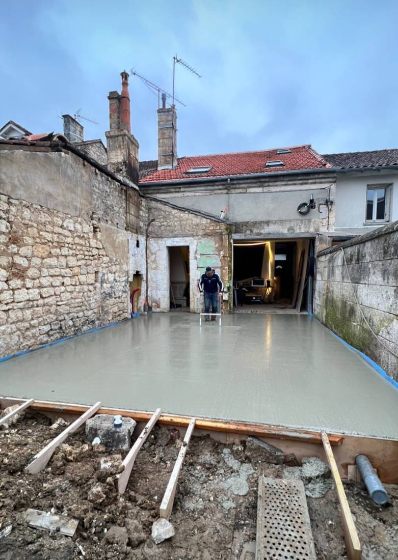 Dalle béton coulée dans une cour en pierre